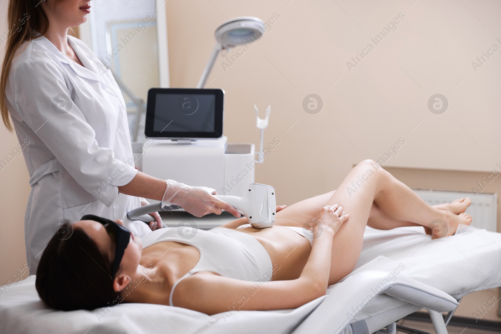 Woman during laser depilation procedure in beauty salon Photo of Woman during laser depilation procedure in beauty salon