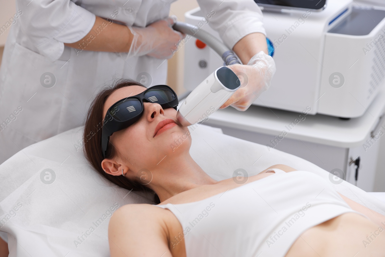Woman during laser depilation procedure in beauty salon Photo of Woman during laser depilation procedure in beauty salon