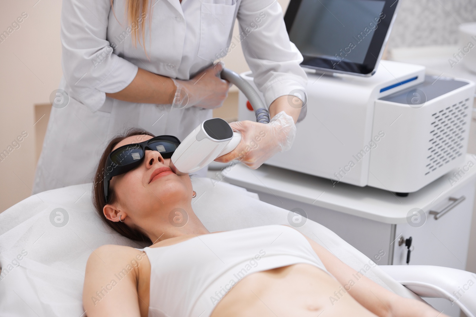 Woman during laser depilation procedure in beauty salon Photo of Woman during laser depilation procedure in beauty salon