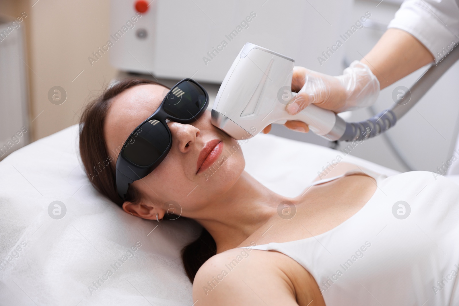 Woman during laser depilation procedure in beauty salon Photo of Woman during laser depilation procedure in beauty salon