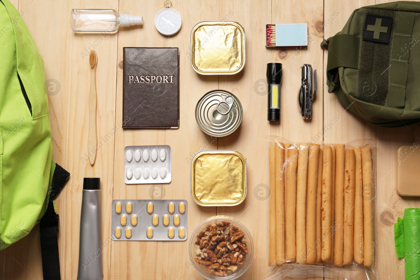 Survival kit. Different emergency supplies on wooden table, flat lay Photo of Survival kit. Different emergency supplies on wooden table, flat lay
