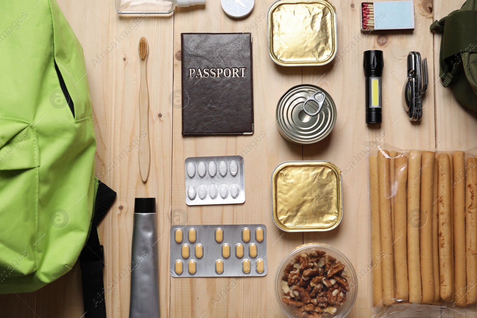 Survival kit. Different emergency supplies on wooden table, flat lay Photo of Survival kit. Different emergency supplies on wooden table, flat lay