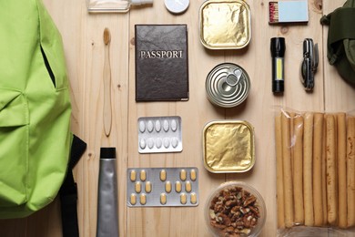 Photo of Survival kit. Different emergency supplies on wooden table, flat lay