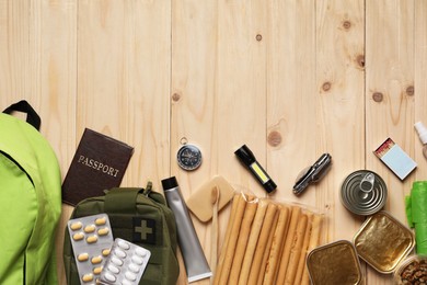 Photo of Survival kit. Different emergency supplies on wooden table, flat lay. Space for text