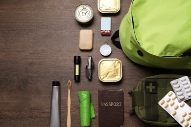 Photo of Survival kit. Different emergency supplies on wooden table, flat lay. Space for text