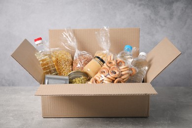 Photo of Different food products in box on gray textured table