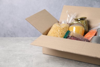 Photo of Different food products in box on gray textured table