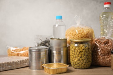 Photo of Different food products on wooden table against gray background
