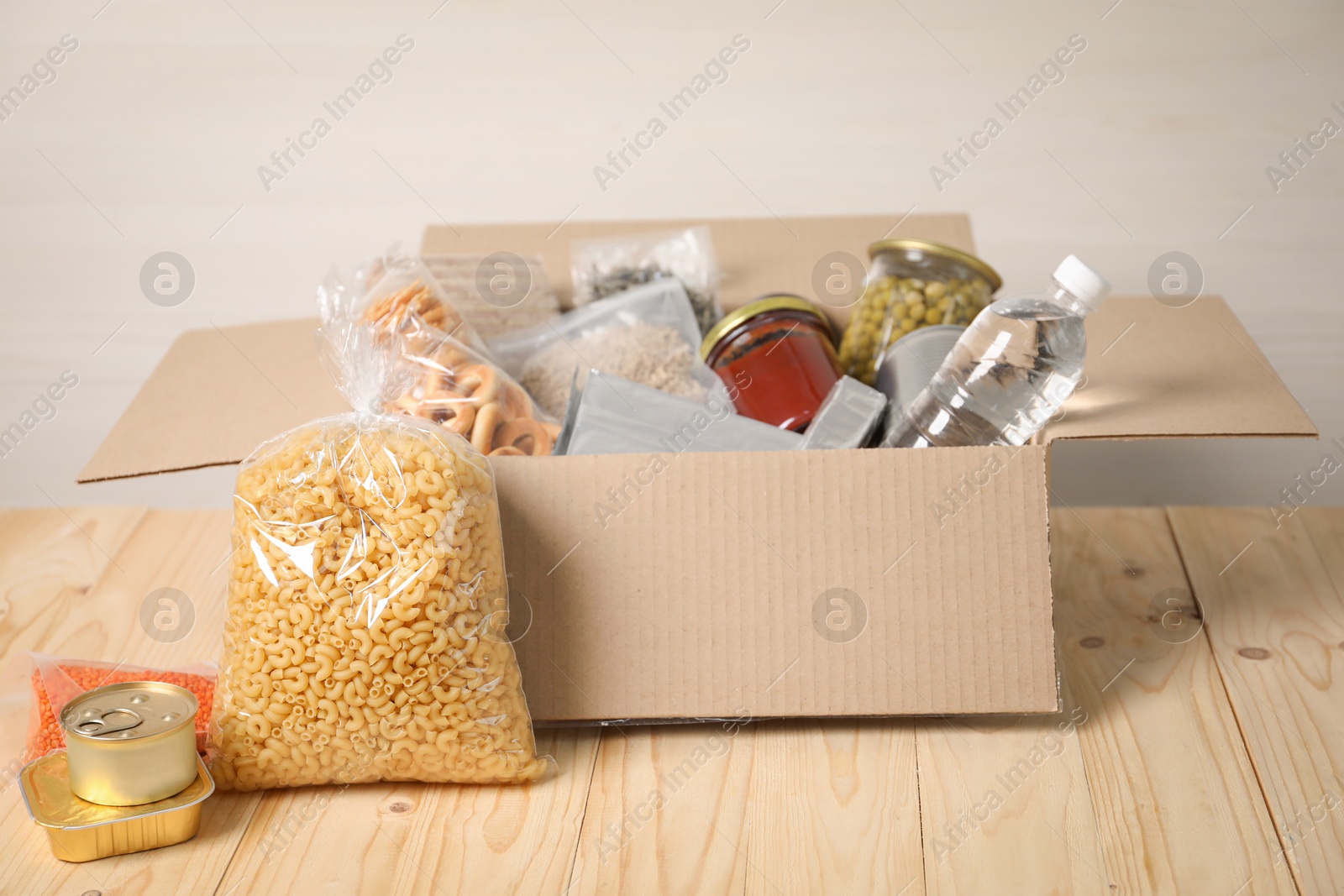Different food products in box on wooden table Photo of Different food products in box on wooden table