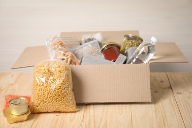 Photo of Different food products in box on wooden table