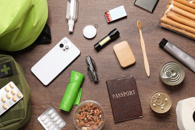 Photo of Survival kit. Different emergency supplies on wooden table, flat lay
