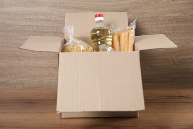 Photo of Different food products in box on wooden table