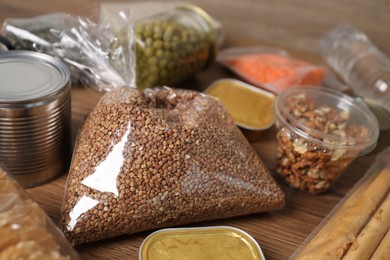 Photo of Different food products on wooden table, closeup