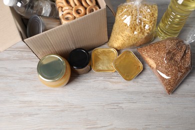 Photo of Different food products and box on wooden table, flat lay. Space for text