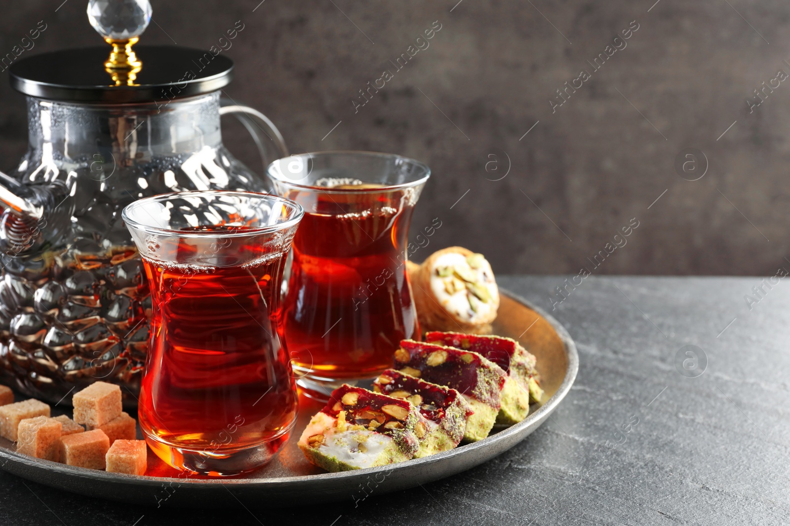 Tasty Turkish tea and delight on black table. Space for text Photo of Tasty Turkish tea and delight on black table. Space for text