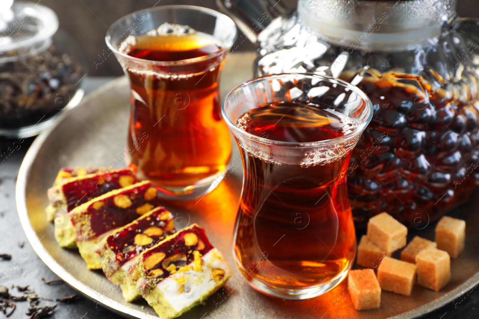 Tasty Turkish tea and delight on black table, closeup Photo of Tasty Turkish tea and delight on black table, closeup