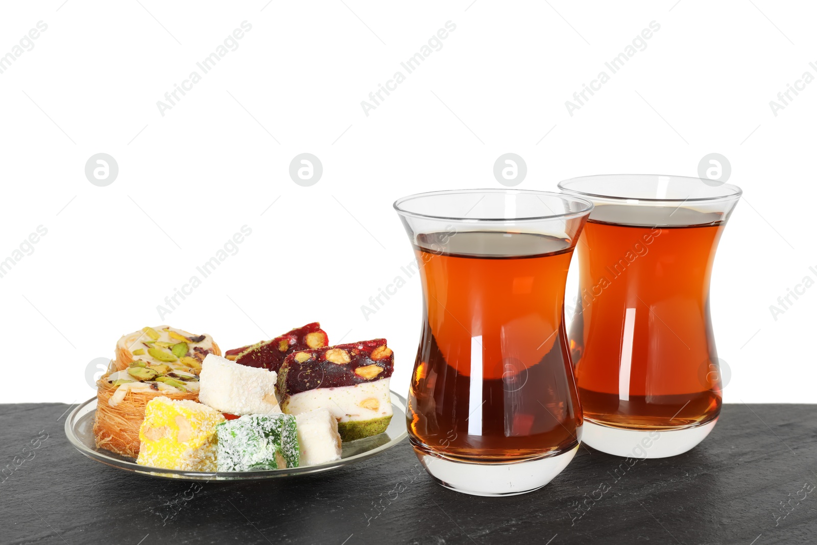 Tasty Turkish tea and delight on table against white background Photo of Tasty Turkish tea and delight on table against white background