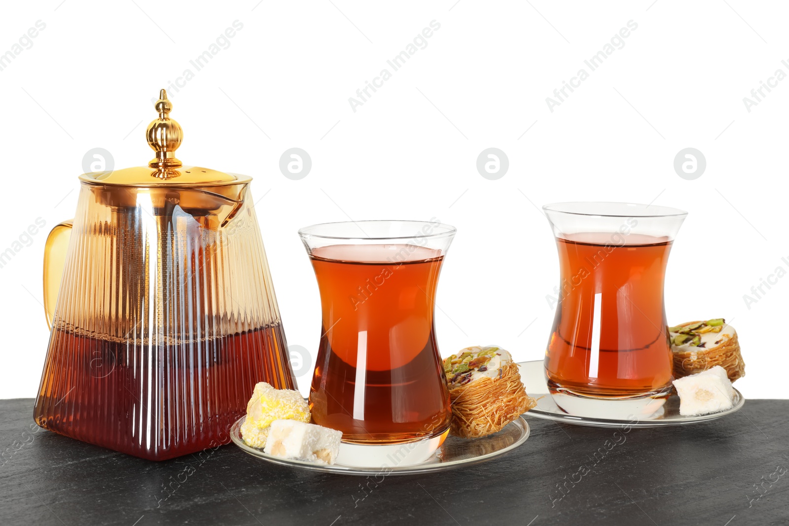 Tasty Turkish tea and delight on table against white background Photo of Tasty Turkish tea and delight on table against white background