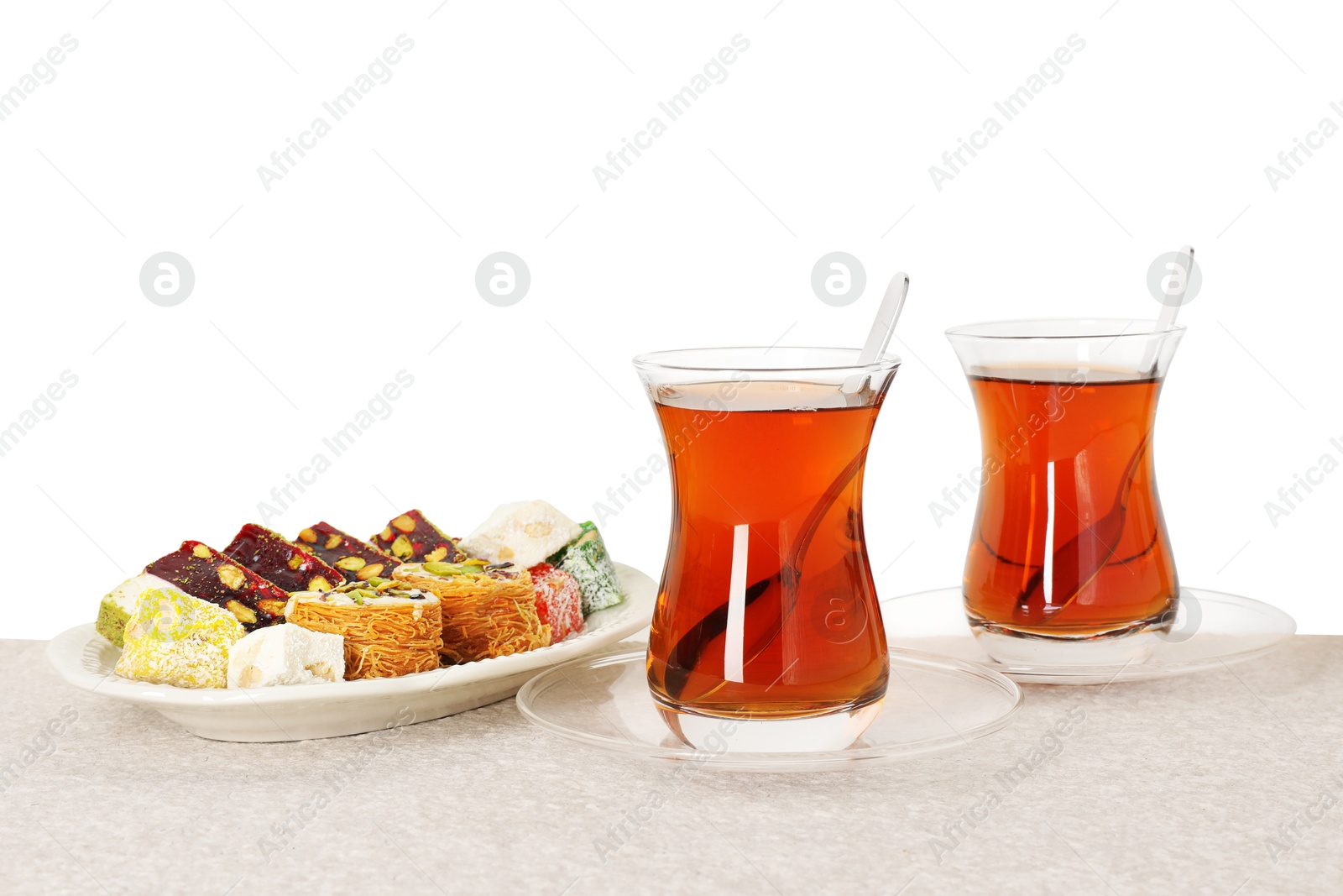 Tasty Turkish tea and delight on table against white background Photo of Tasty Turkish tea and delight on table against white background
