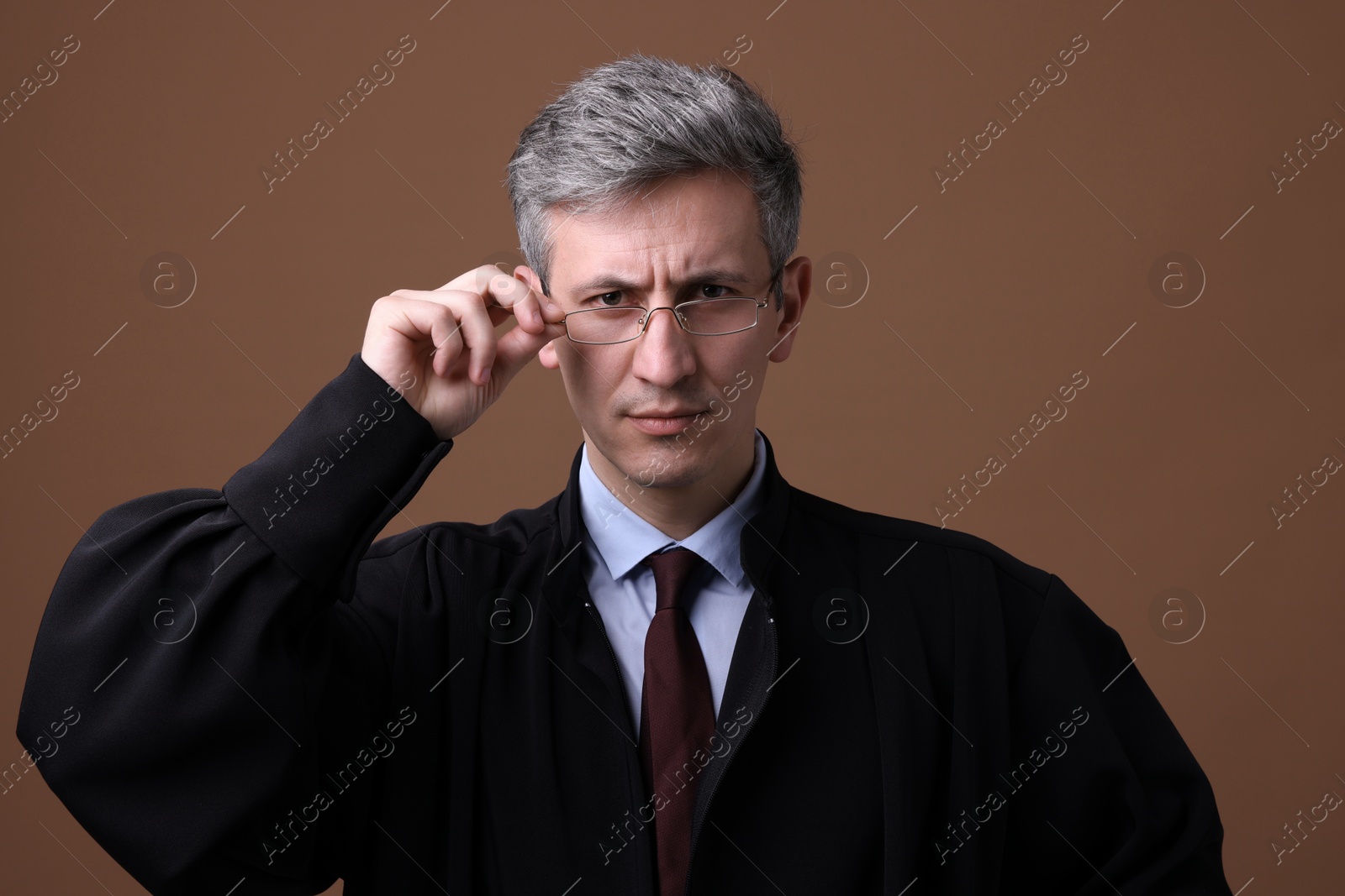 Judge in court dress on brown background Photo of Judge in court dress on brown background