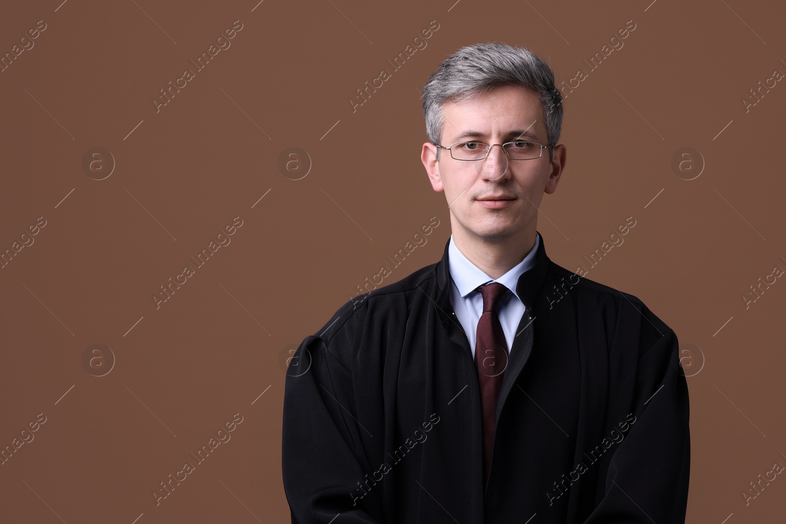 Judge in court dress on brown background. Space for text Photo of Judge in court dress on brown background. Space for text