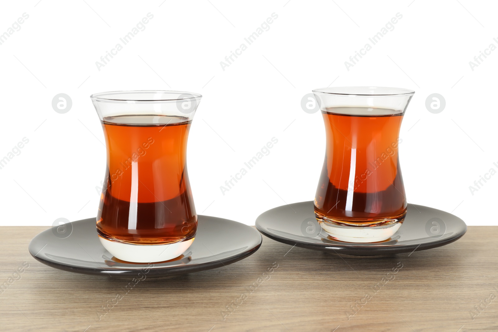 Tasty Turkish tea in cups on wooden table against white background Photo of Tasty Turkish tea in cups on wooden table against white background