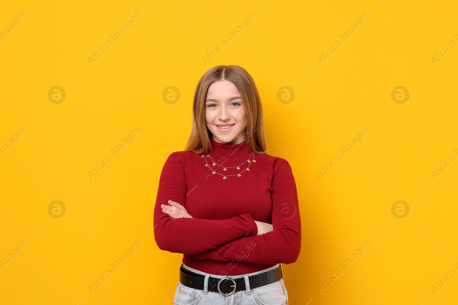Photo of Portrait of smiling teenage girl on yellow background