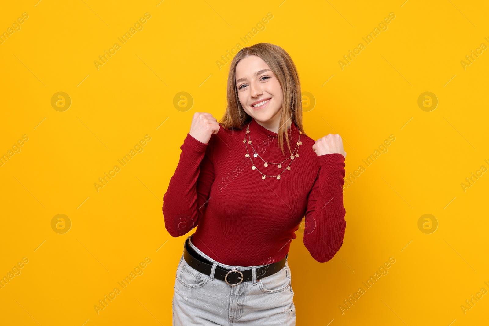 Photo of Portrait of smiling teenage girl on yellow background