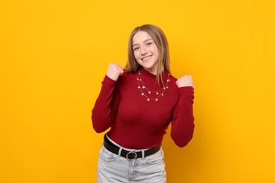 Photo of Portrait of smiling teenage girl on yellow background