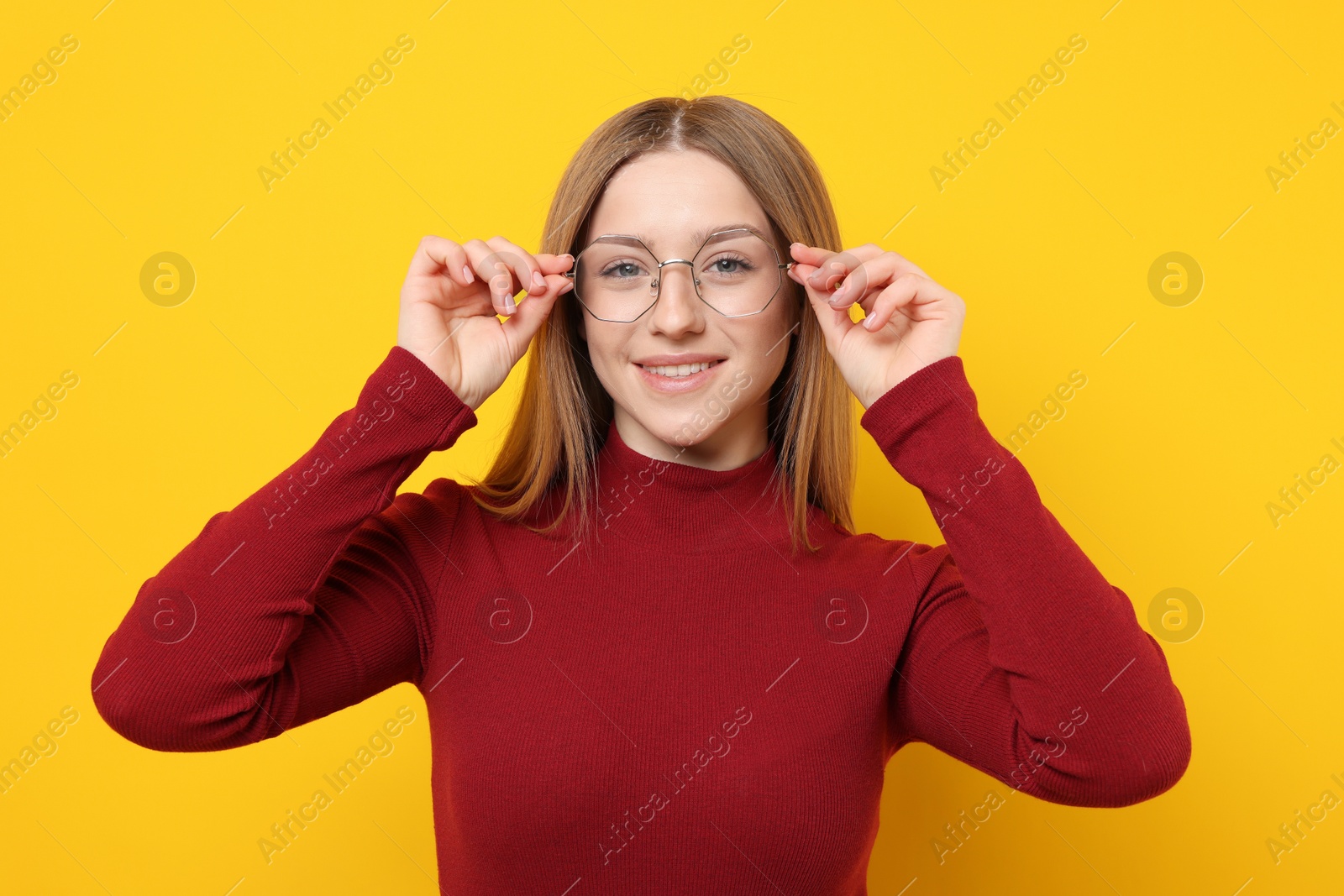 Photo of Portrait of smiling teenage girl on yellow background