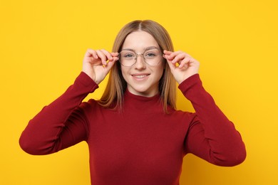 Photo of Portrait of smiling teenage girl on yellow background