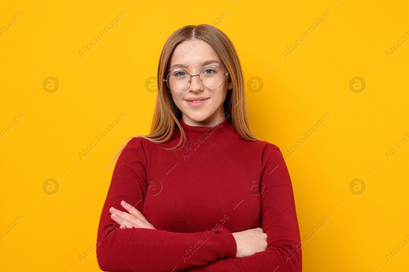 Photo of Portrait of smiling teenage girl on yellow background
