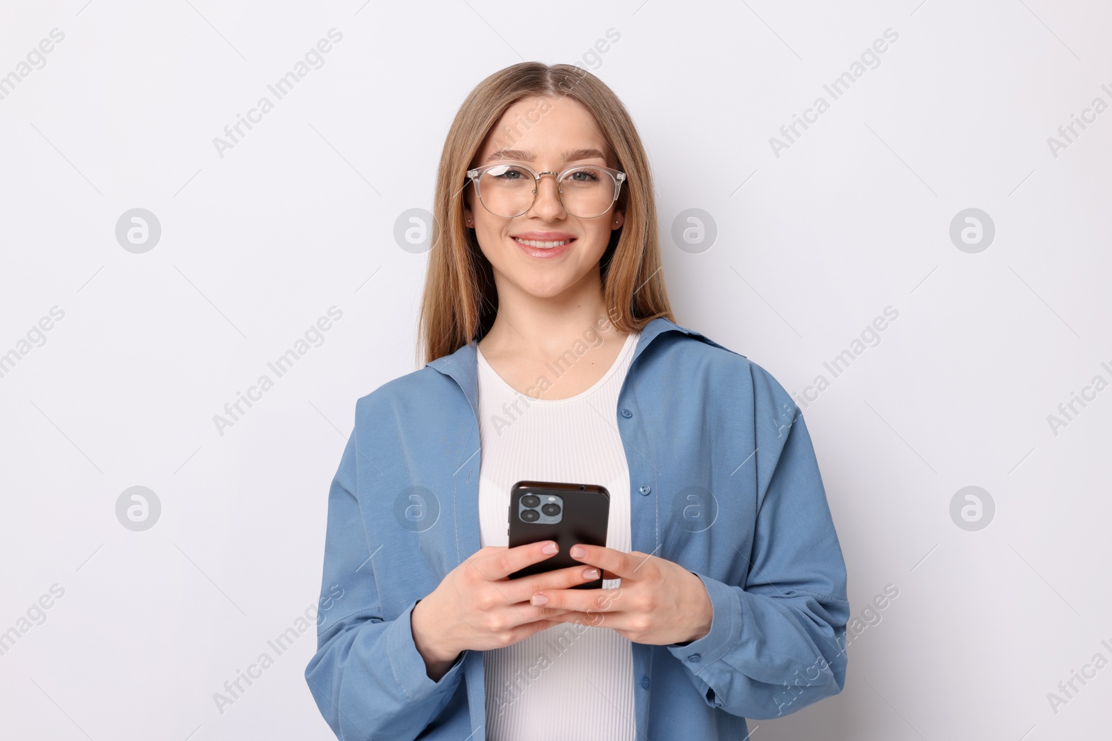 Photo of Portrait of smiling teenage girl with smartphone on white background