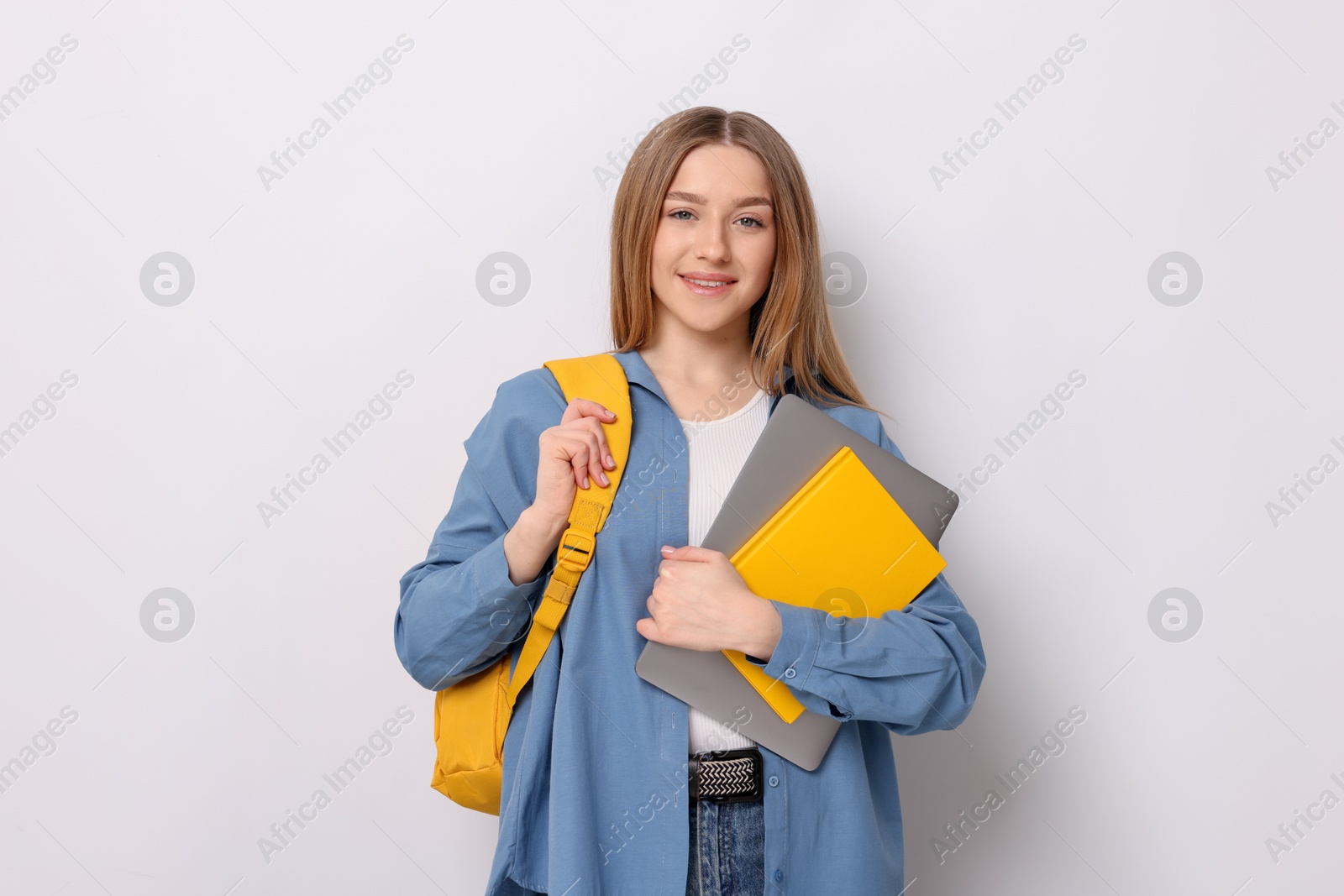 Smiling teenage girl with books and backpack on white background Photo of Smiling teenage girl with books and backpack on white background