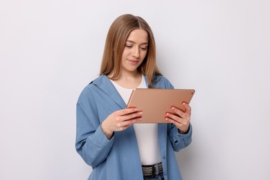 Photo of Beautiful teenage girl with tablet on white background