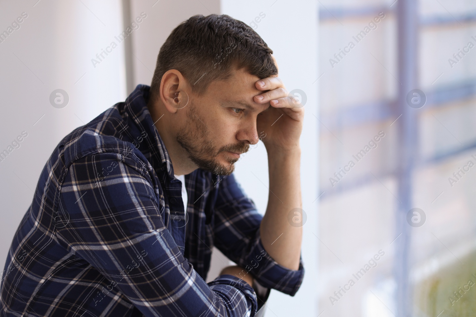 Depressed man near window in building. Mental health problem Photo of Depressed man near window in building. Mental health problem