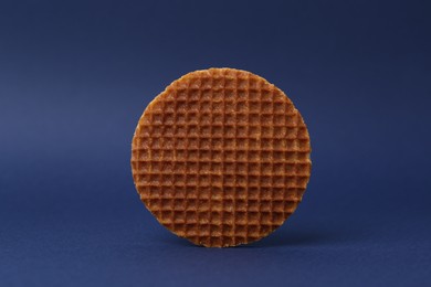 Photo of One tasty round waffle on blue background