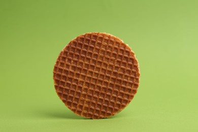 Photo of One tasty round waffle on green background