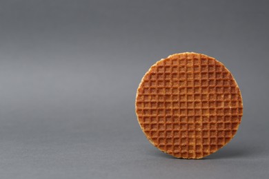Photo of One tasty round waffle on grey background. Space for text