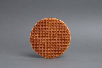 Photo of One tasty round waffle on grey background