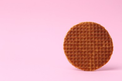 Photo of One tasty round waffle on pink background. Space for text