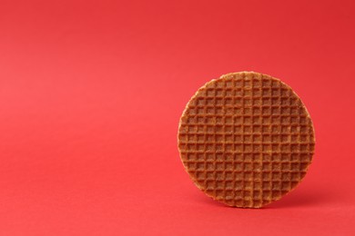 Photo of One tasty round waffle on red background. Space for text