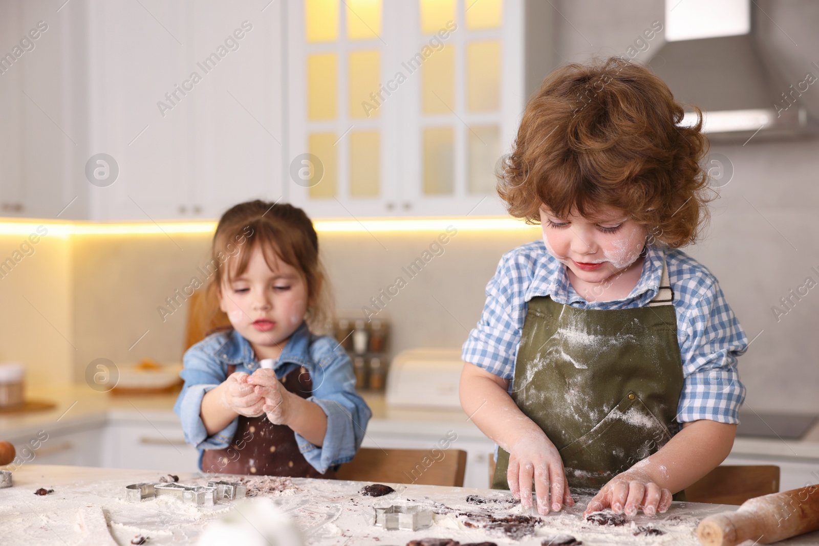 Cooking recipe. Little children cutting cookie dough with cutters at table indoors Photo of Cooking recipe. Little children cutting cookie dough with cutters at table indoors