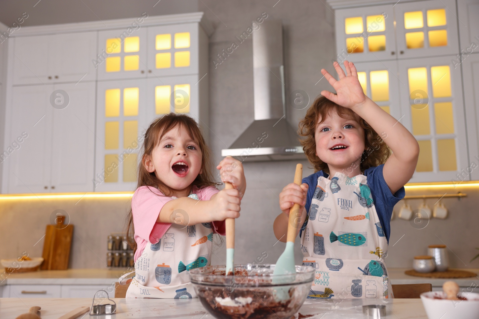 Cooking recipe. Cute children mixing dough for cookies at table in kitchen Photo of Cooking recipe. Cute children mixing dough for cookies at table in kitchen