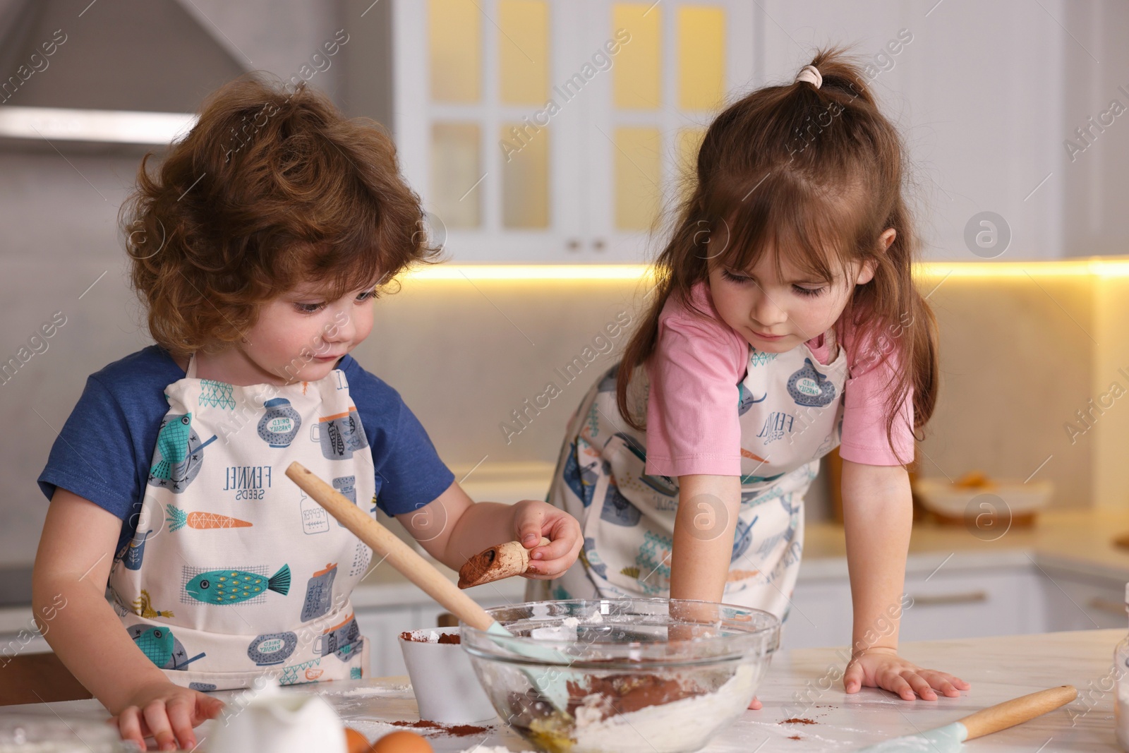 Cooking recipe. Cute children making dough for cookies at table in kitchen Photo of Cooking recipe. Cute children making dough for cookies at table in kitchen