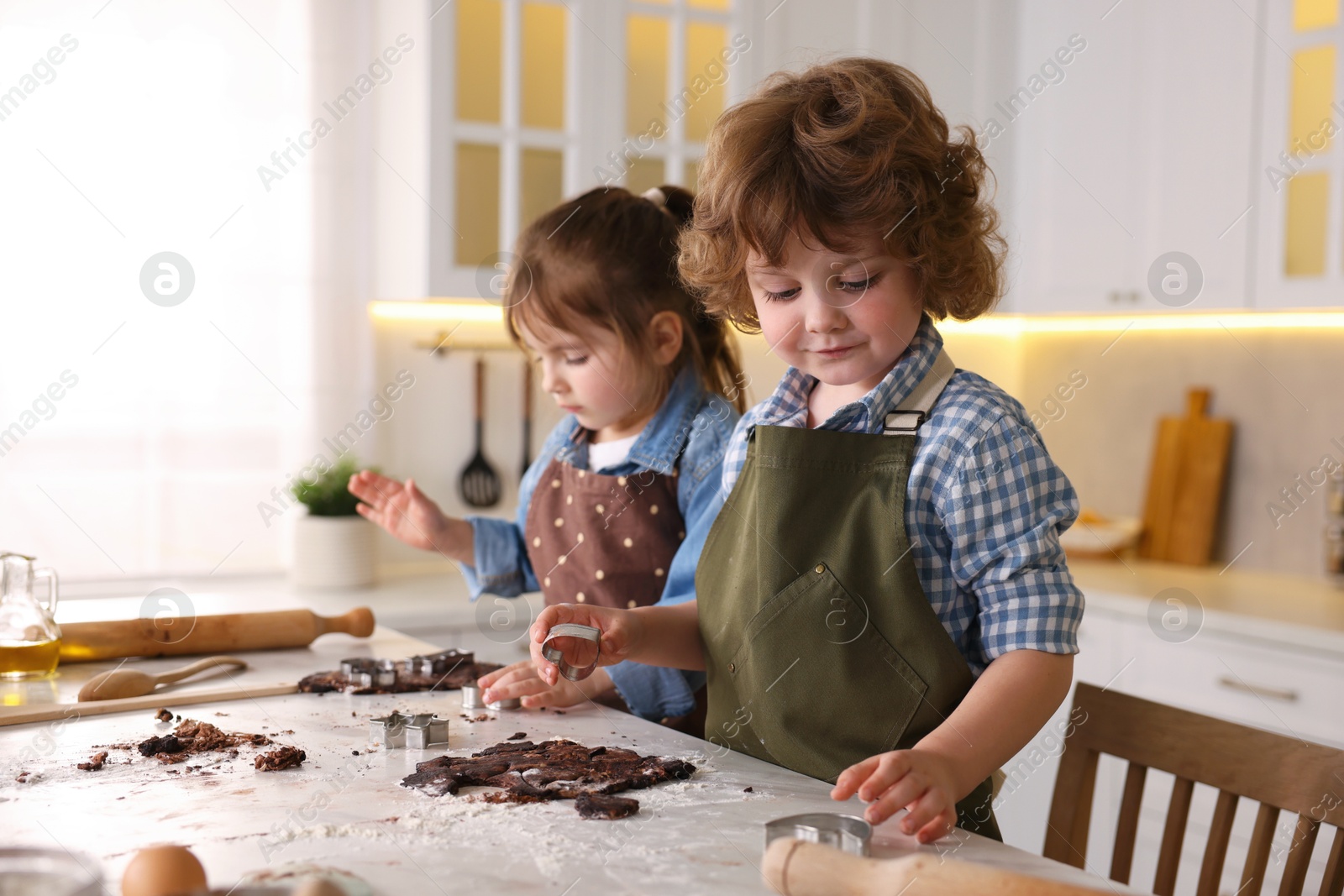 Cooking recipe. Little children cutting cookie dough with cutters at table indoors Photo of Cooking recipe. Little children cutting cookie dough with cutters at table indoors