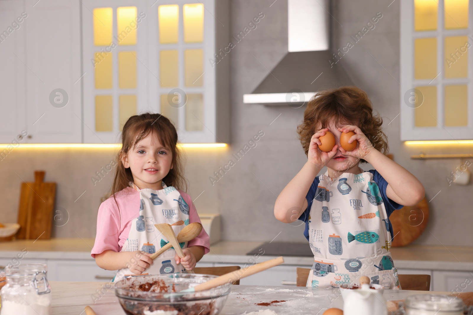 Little children having fun while cooking in kitchen Photo of Little children having fun while cooking in kitchen