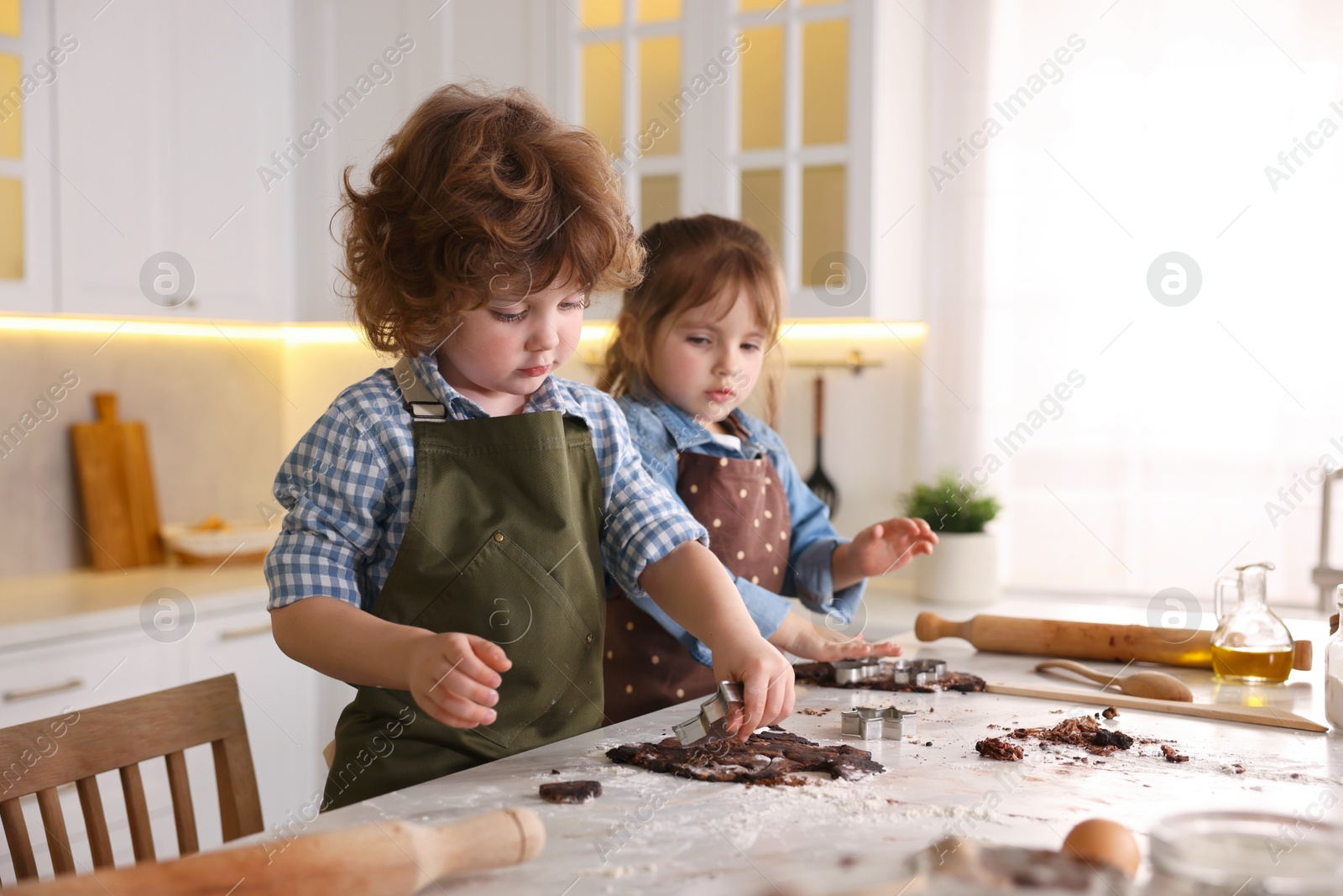 Cooking recipe. Little children cutting cookie dough with cutters at table indoors Photo of Cooking recipe. Little children cutting cookie dough with cutters at table indoors