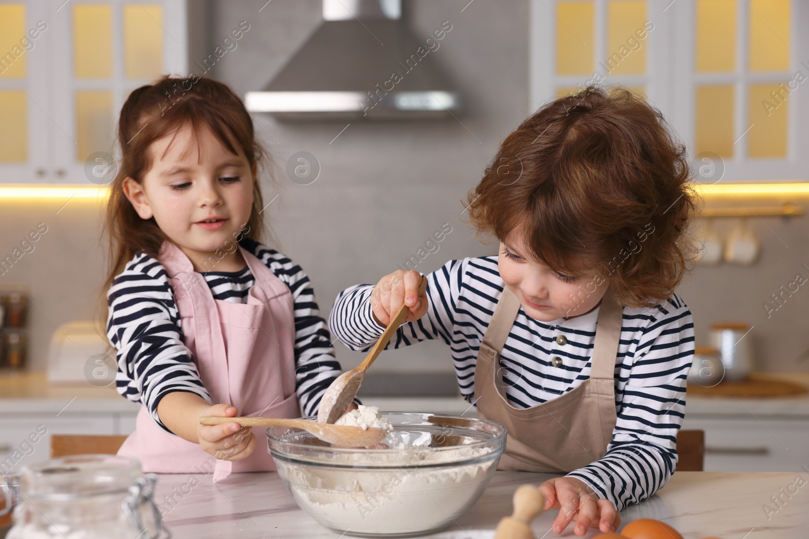 Cooking recipe. Cute children making dough for cookies at table in kitchen Photo of Cooking recipe. Cute children making dough for cookies at table in kitchen