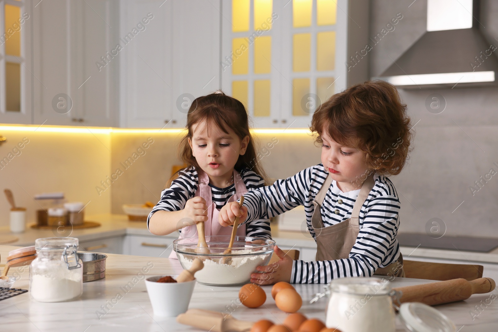 Cooking recipe. Cute children making dough for cookies at table in kitchen Photo of Cooking recipe. Cute children making dough for cookies at table in kitchen